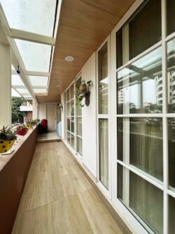 An elegant and low-maintenance outdoor retreat Modern balcony with white UPVC windows and a wood-look PVC false ceiling