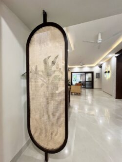 Beautifully divided, seamlessly connected. Elegant curved cane partition separating living and dining area in a Japandi-style home