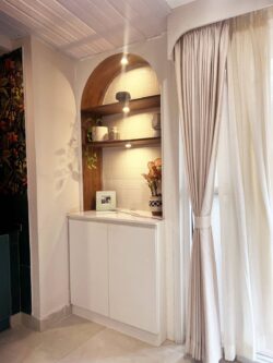 Your personal pub, perfected. Elegant japandi-style home bar counter with wooden top and glass shelving in Bangalore residence