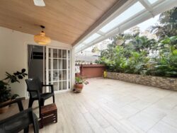 Your personal patch of green in the city. A spacious balcony extending into a small courtyard with built-in planters and lush greenery.