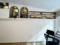 Where productivity meets artistry. A modern home office with custom curved wall-mounted bookshelves and a built-in desk.